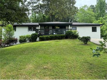 Mid-century modern ranch house featuring a freshly painted exterior and deck at 2023 Lee Dr, Austell, GA 30168