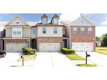 Three-story townhouses with attached garages and manicured landscaping at 2386 Bellyard Dr, Buford, GA 30519