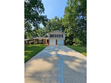 Two-story house with attached garage and a well-manicured lawn at 4670 Eberline Ct, Stone Mountain, GA 30083