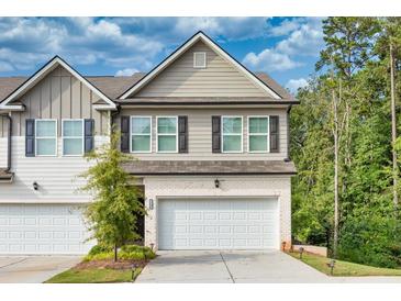Two-story townhome with attached garage and landscaping at 5586 Cannonade Ln, Stonecrest, GA 30058