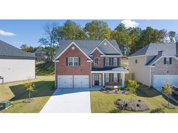 Brick two-story house with a two-car garage and landscaped yard at 1641 Lacebark Elm Way, Lawrenceville, GA 30045
