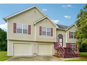 House exterior featuring a two-car garage and charming front porch at 376 Cattlemans Cir, Mcdonough, GA 30252