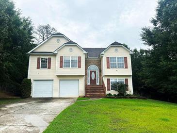 Two-story house with two-car garage and landscaping at 3393 Madison Farm Way, Snellville, GA 30039