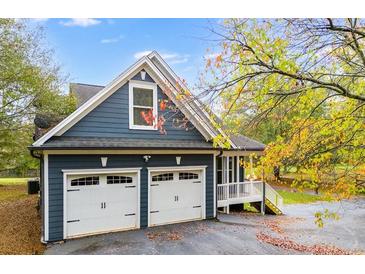 Two-car garage with white doors and gray exterior at 210 Pine Valley Rd, Hiram, GA 30141