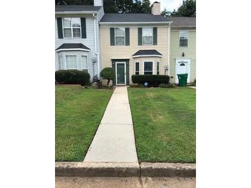 Two-story townhouse with green lawn and walkway at 5632 Stonington Trace Pkwy, Stone Mountain, GA 30087