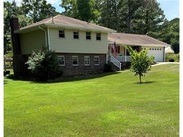 Two-story house with brick and siding, attached garage, and well-maintained lawn at 2079 Christian Se Cir, Conyers, GA 30013