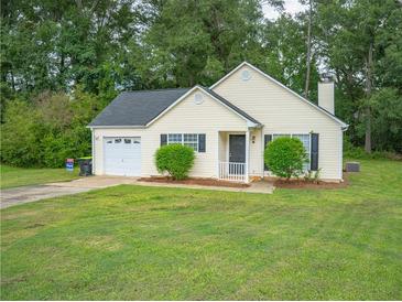 Yellow house with attached garage and large yard at 15 Marissa Cv, Riverdale, GA 30274