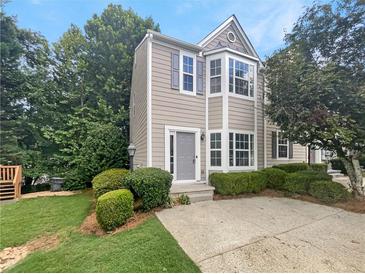 Two-story townhome exterior with gray siding, landscaping and a paved driveway at 5319 Pinnacle Peak Ln, Norcross, GA 30071