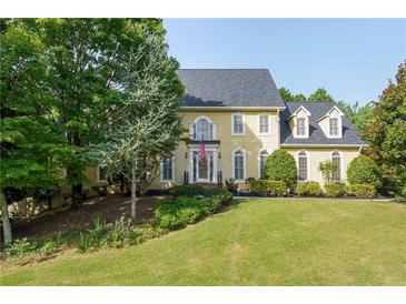 Beautiful two-story house with a manicured lawn and mature trees at 1357 Baniff Ct, Snellville, GA 30078