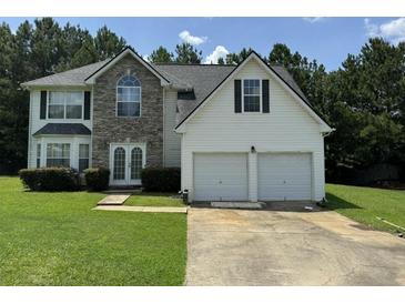 Two-story house with a two-car garage and stone accents at 2112 Bradford Pear Se Cir, Conyers, GA 30013