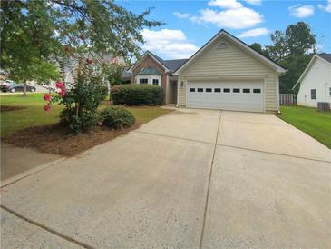 Cute house with a two-car garage and manicured lawn at 424 Eglington Trl, Locust Grove, GA 30248