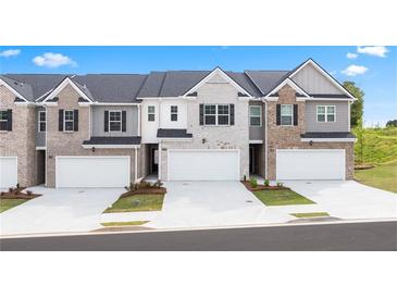 Three townhouses with attached garages and landscaping at 305 Silver Moon Dr, Loganville, GA 30052
