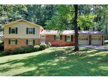 Brick ranch house with a two-car garage and a spacious lawn at 2802 Leisure Woods Ln, Decatur, GA 30034