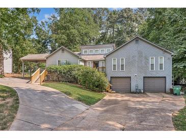 Gray two-story house with double garage, landscaped yard and a long driveway at 5833 Wind Haven Nw Ct, Kennesaw, GA 30152