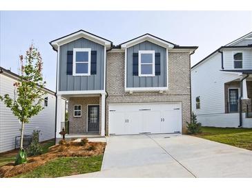 Two-story house featuring gray and tan brick exterior, two-car garage, and landscaping at 2760 Hawthorne Way, College Park, GA 30337