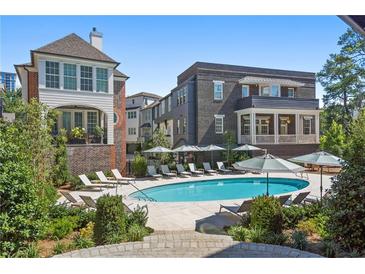 Community pool with lounge chairs and umbrellas at 100 Ottley Ln, Atlanta, GA 30305