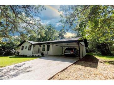 White ranch house with carport and landscaped yard at 6733 Walker Rd, Riverdale, GA 30296