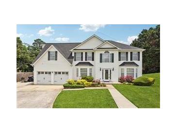 Two story home with a three car garage and manicured lawn at 1760 Waterton Ln, Lithonia, GA 30058