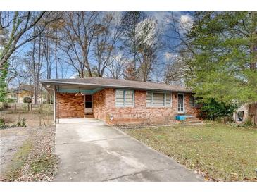 Brick ranch house with attached carport and landscaped yard at 4928 Glaze Dr, Atlanta, GA 30360