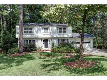 Two-story house with white brick, black door, and landscaped yard at 873 Hearthstone Dr, Stone Mountain, GA 30083