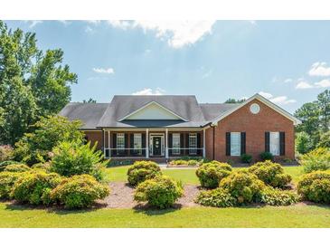 Brick house with a front porch, nicely landscaped lawn, and large windows at 12 Ivy Chase Nw Way, Cartersville, GA 30121