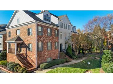 Brick townhome with a charming front porch and landscaped lawn at 222 Le Gran Vw, Atlanta, GA 30328