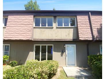 Two-story townhome with brown roof and mature shrubbery at 1189 Ashborough Se Dr # K, Marietta, GA 30067