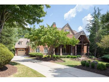 Brick house with a large front porch and landscaping at 858 Middle Fork Trl, Suwanee, GA 30024