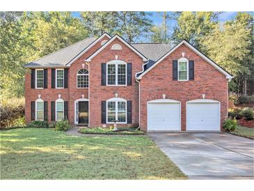 Brick house with two car garage and a manicured lawn at 2049 Town Square Dr, Mcdonough, GA 30253