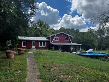Red house with a large yard and above ground pool at 268 Arnold Mill Rd, Woodstock, GA 30188