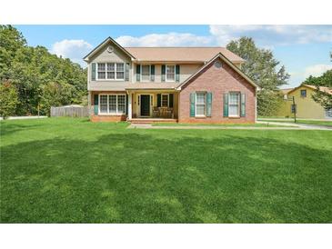 Two-story brick and vinyl home with green lawn at 9334 Woodsboro Ct, Jonesboro, GA 30236