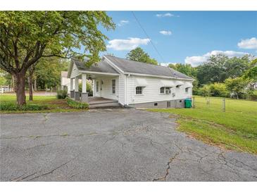 White house with front porch, driveway, and yard at 5665 Austell Powder Springs Rd, Austell, GA 30106