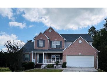 Brick two-story house with a two-car garage and a covered porch at 1321 Webb Farm Ln, Loganville, GA 30052