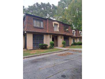 Condo building exterior, brown roof, tan siding, landscaping, and parking at 2968 Parc Lorraine, Lithonia, GA 30038