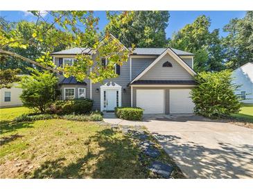 Two-story house with gray siding, two-car garage, and landscaped yard at 4959 Abbotts Glen Nw Trl, Acworth, GA 30101