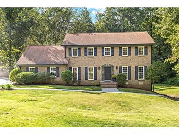 Brick two-story home with shutters, landscaping, and a welcoming front porch at 1972 Peeler Rd, Atlanta, GA 30338