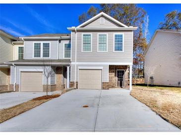 Two-story townhome with attached garage and brick accents at 6186 Ripple Way # 84, South Fulton, GA 30349