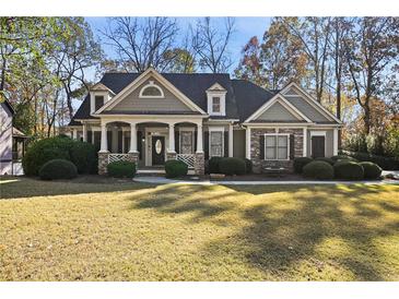 Two-story house with stone accents, large front porch, and landscaped lawn at 403 Pebblebrooke Ln, Canton, GA 30115