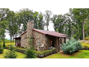 Rustic stone house with a covered porch and beautiful landscaping at 1625 Brushy Mountain Rd, Rockmart, GA 30153