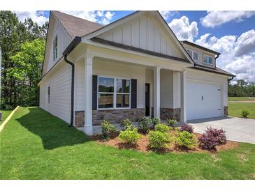 Cream-colored house with a front porch, stone accents, and a two-car garage at 111 Sunflower Ne Cir, Cartersville, GA 30121