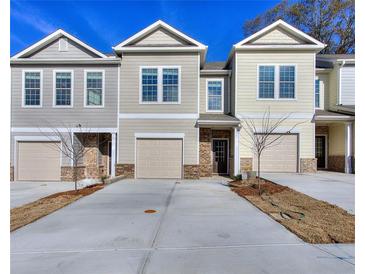 Two-story beige and gray townhouses with garages at 6194 Ripple Way # 86, South Fulton, GA 30349
