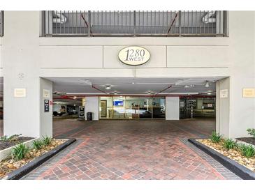 Modern building entrance with brick paved pathway, leading to a secure parking garage at 1280 W Peachtree Nw St # 3114, Atlanta, GA 30309