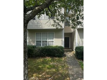 Tan two-story home exterior with manicured hedges and walkway at 119 Odyssey Turn, Conyers, GA 30012