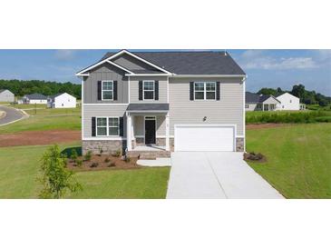 Two story house with gray siding, stone accents and a two car garage at 613 Kimberwick Dr, Locust Grove, GA 30248