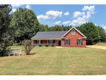 Brick ranch house with front porch and large yard at 80 Stewart Hollow Ln, Covington, GA 30016