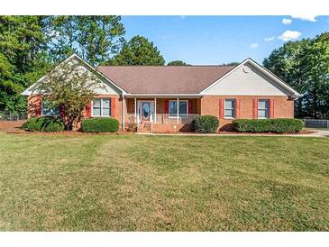 Brick ranch house with red shutters and large yard at 497 Freedom Dr, Mcdonough, GA 30252