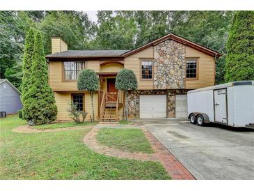 House exterior featuring stone accents and two-car garage at 1922 Marshes Glenn Dr, Norcross, GA 30071