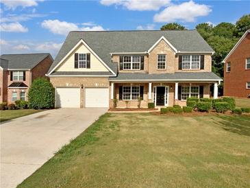 Two-story house with two-car garage and landscaping at 1340 Lower Falls Dr, Mcdonough, GA 30252