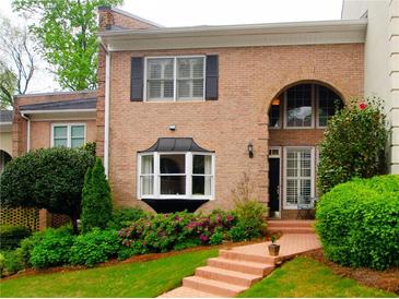 Brick townhouse with bay window, landscaped yard, and walkway at 3021 Margaret Mitchell Dr # 8, Atlanta, GA 30327