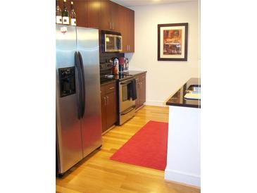 Modern kitchen with stainless steel appliances, dark wood cabinets, and hardwood floors at 44 Peachtree Ne Pl # 424, Atlanta, GA 30309